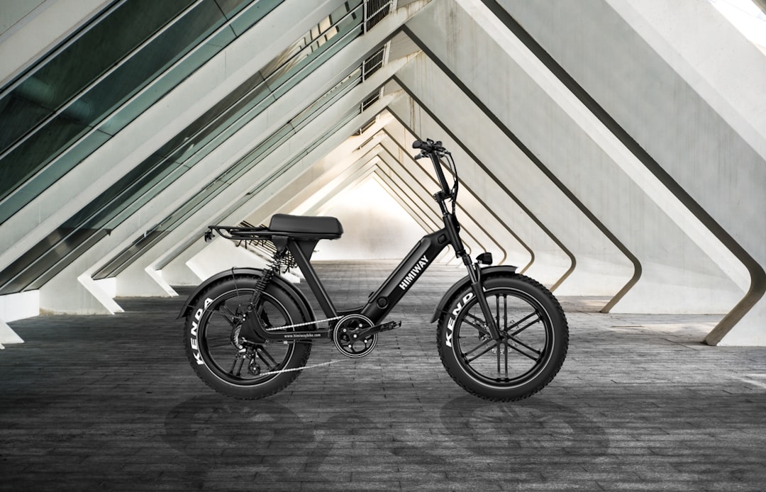 En svart elcykel i en arkitektonisk betongmiljö