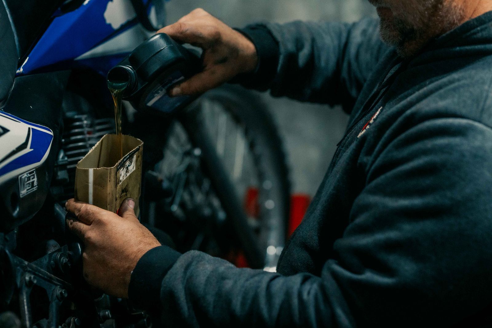 Mekaniker häller motorolja i en motorcykel