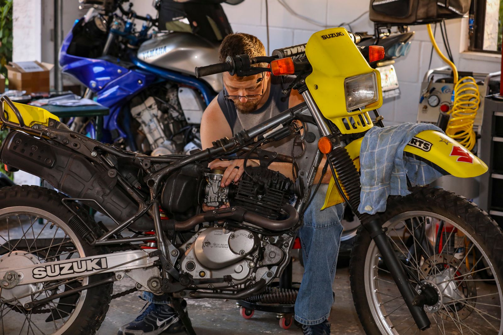 Mekaniker som reparerar en Suzuki-motorcykel i verkstad