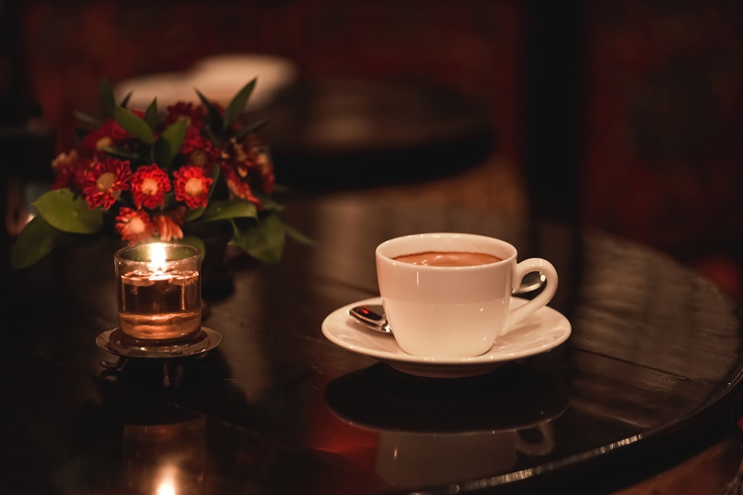 Kaffekopp bredvid ett tänt ljus på kvällen