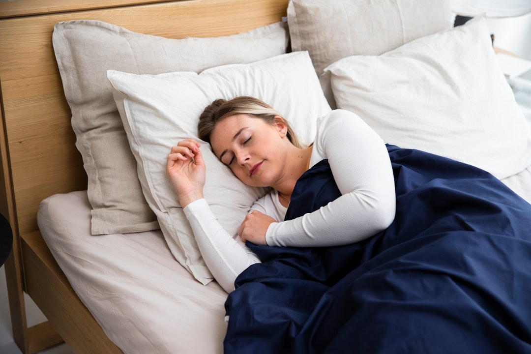 Kvinna som sover på sidan med huvudet på kudden