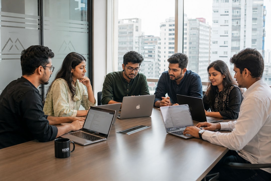 Företagsteam diskuterar vid ett bord med laptops