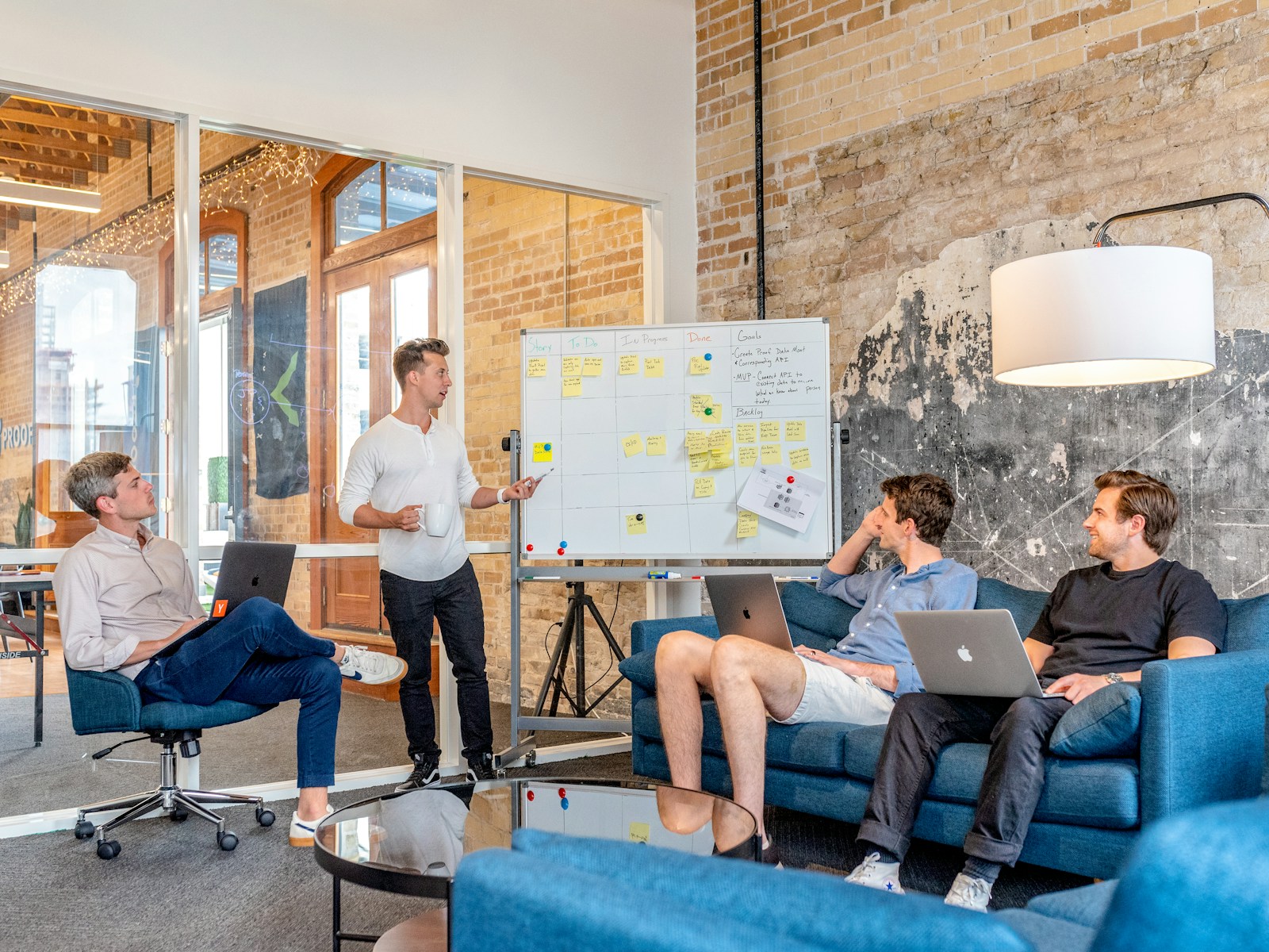 Ett växande team planerar arbetet tillsammans vid en whiteboard med gula lappar