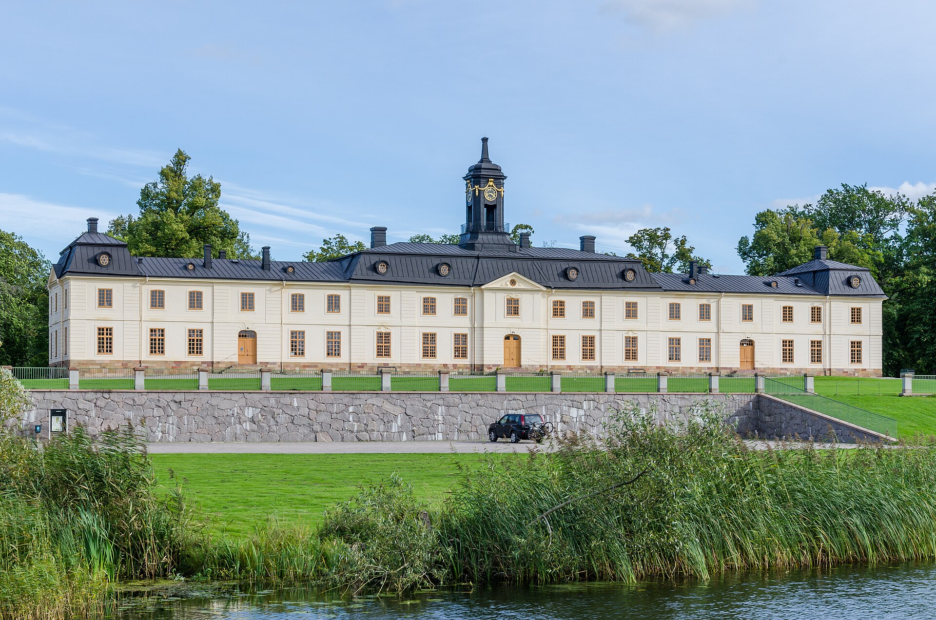 Svartsjö slotts symmetriska fasad med klocklanternin, sedd över Svartsjöviken