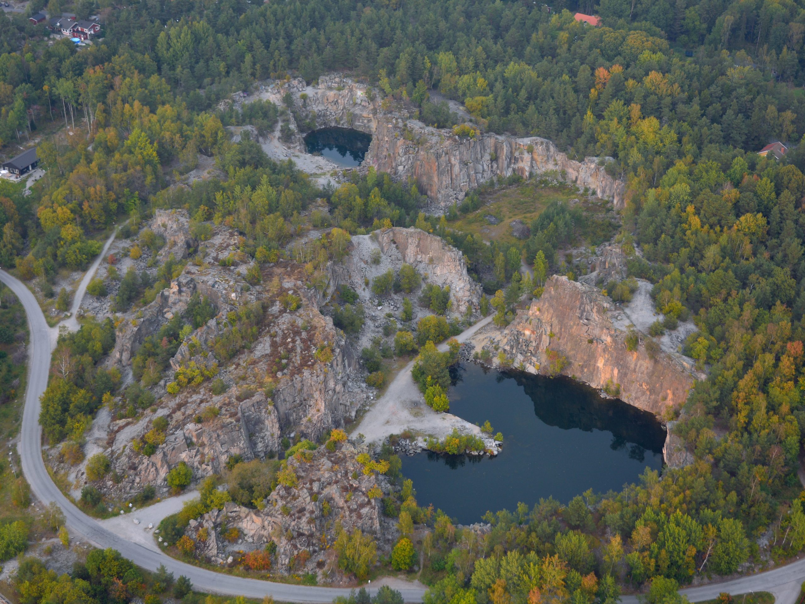 Flygfoto över de vattenfyllda dagbrotten i Stenhamra stenbrott på Färingsö