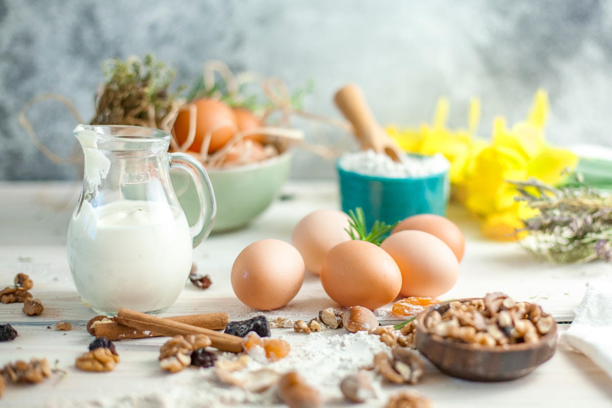 Ägg, mjölk, nötter och torkad frukt på ett köksbord
