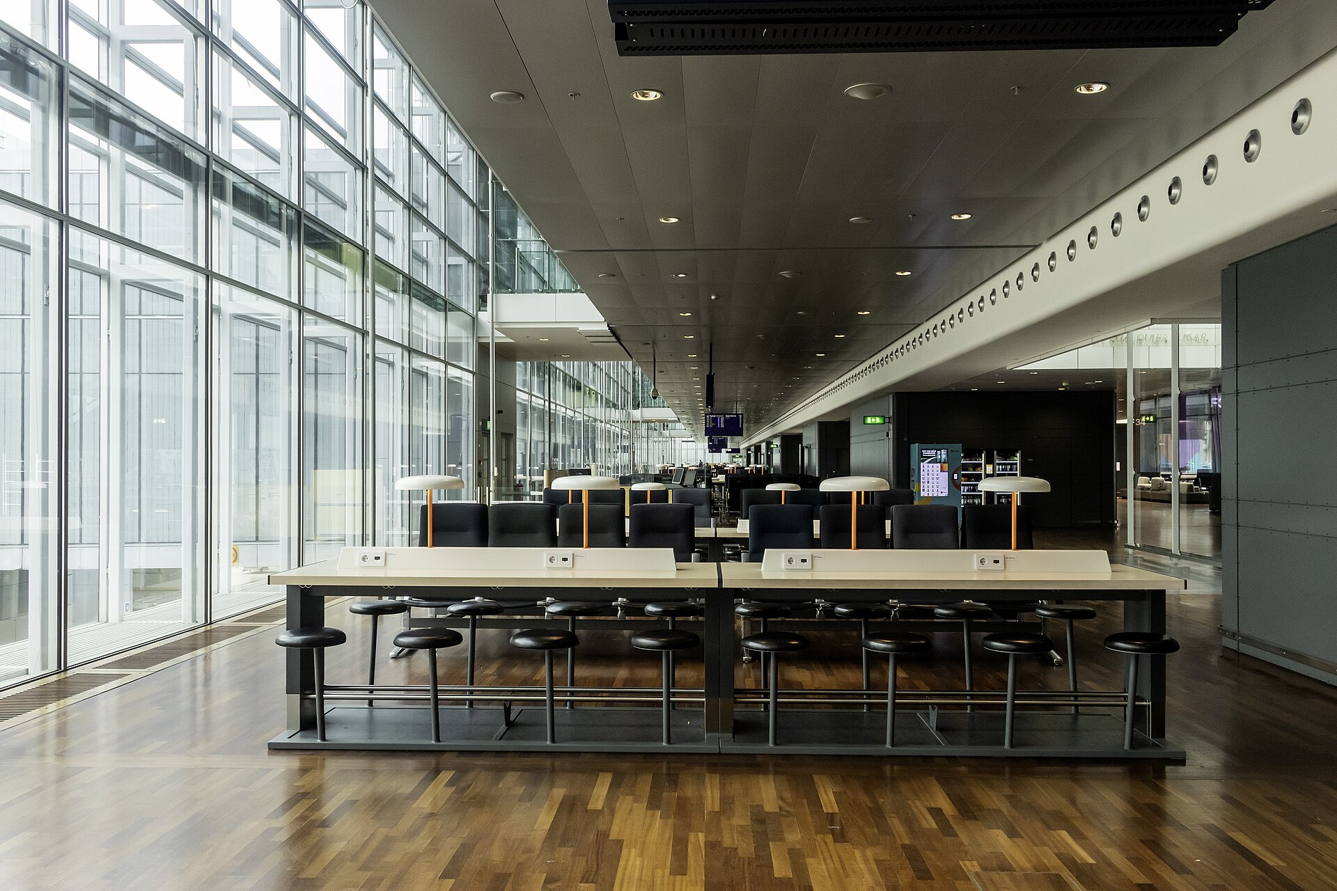 Avgångshallen i terminal 5 på Arlanda med glasfasad och ståbord