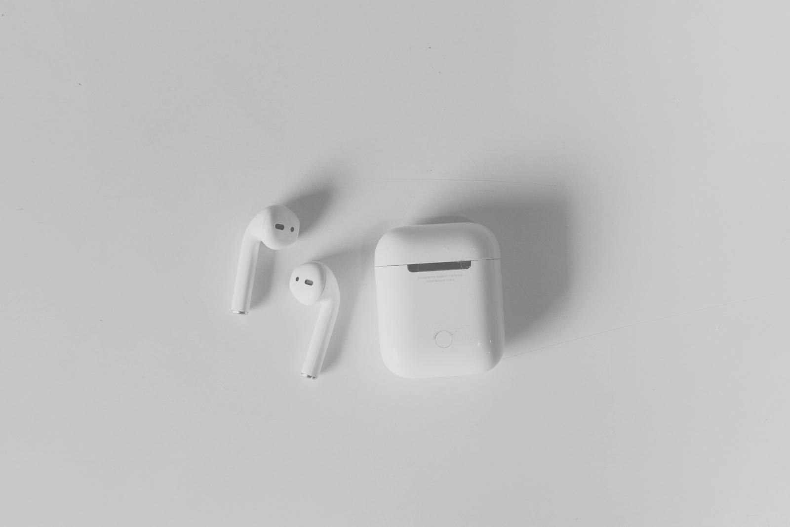 AirPods och laddfodral i närbild på ljus bakgrund