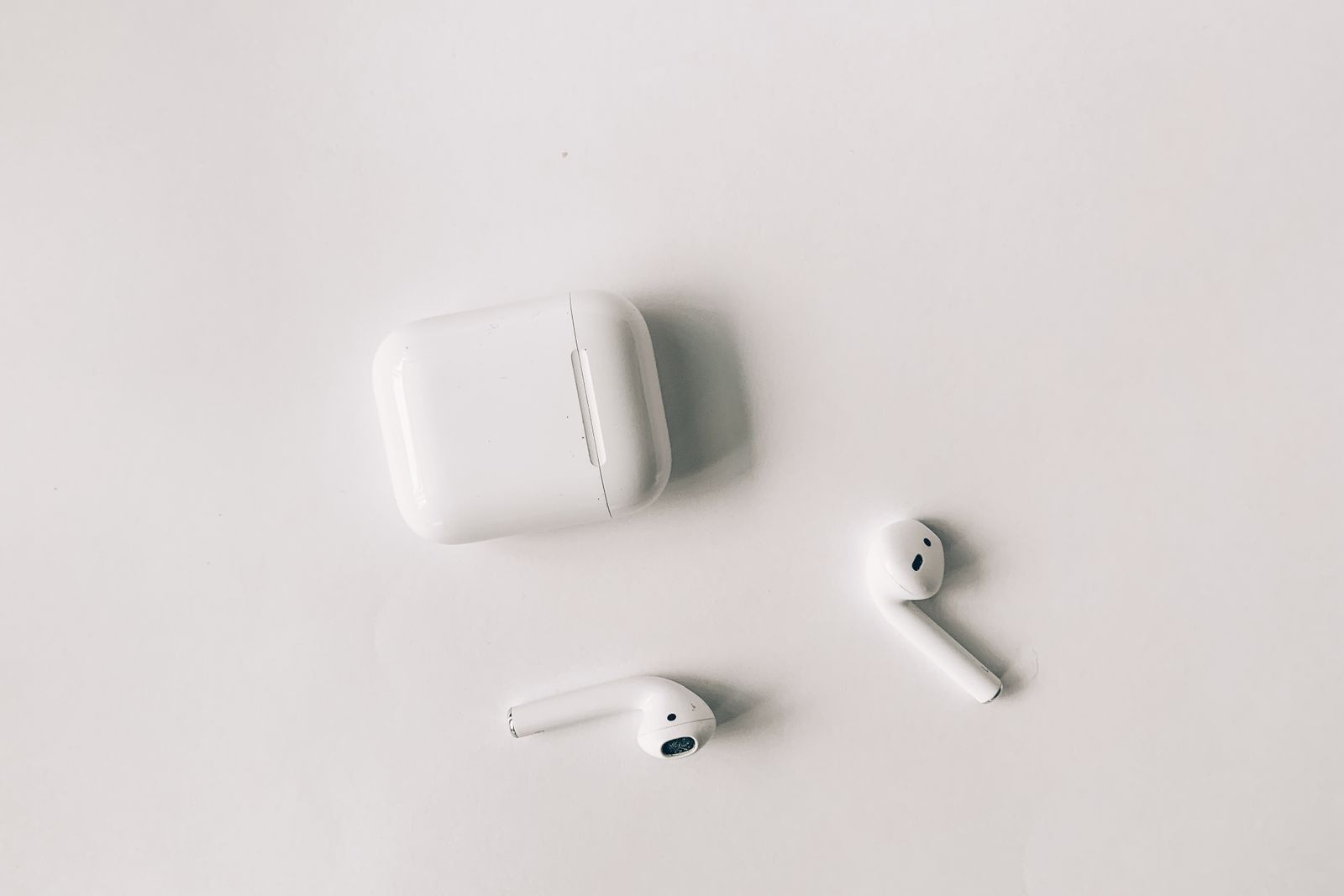 AirPods och laddfodral på ljus bakgrund