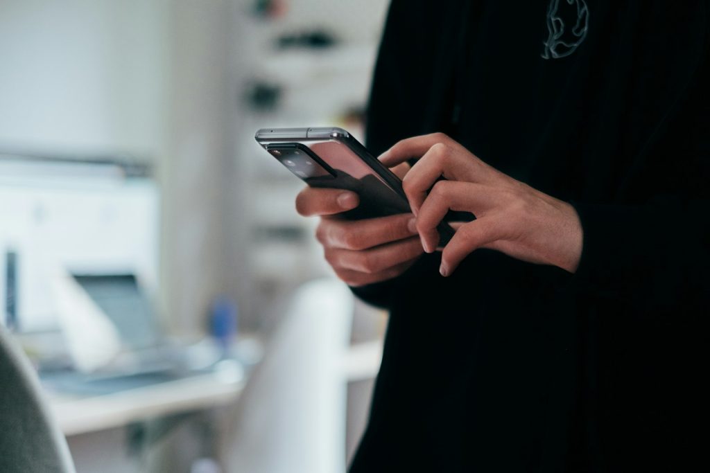 En person skriver ett meddelande på en mobiltelefon