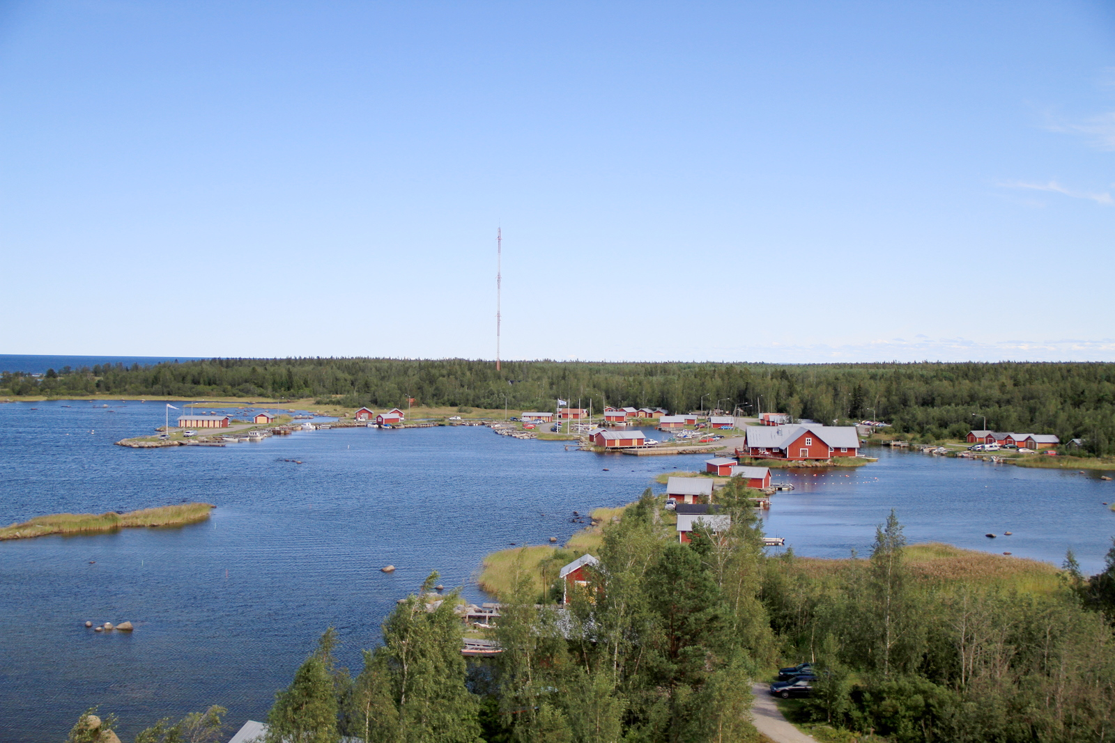 Svedjehamn i Kvarkens skärgård i Finland, sett från utsiktstornet Saltkaret, med röda båthus vid en lugn vik
