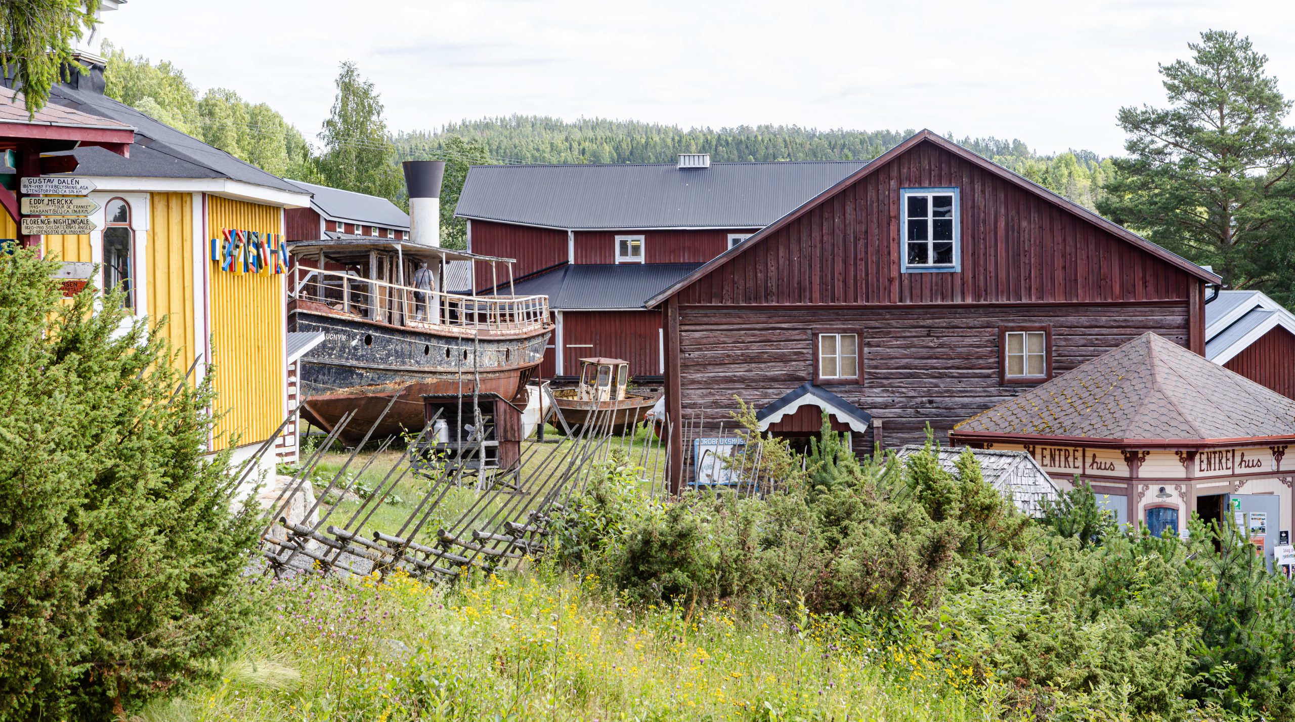 Byggnader i olika stilar tätt intill varandra på Mannaminne i Häggvik, med en uppdragen ångbåt framför
