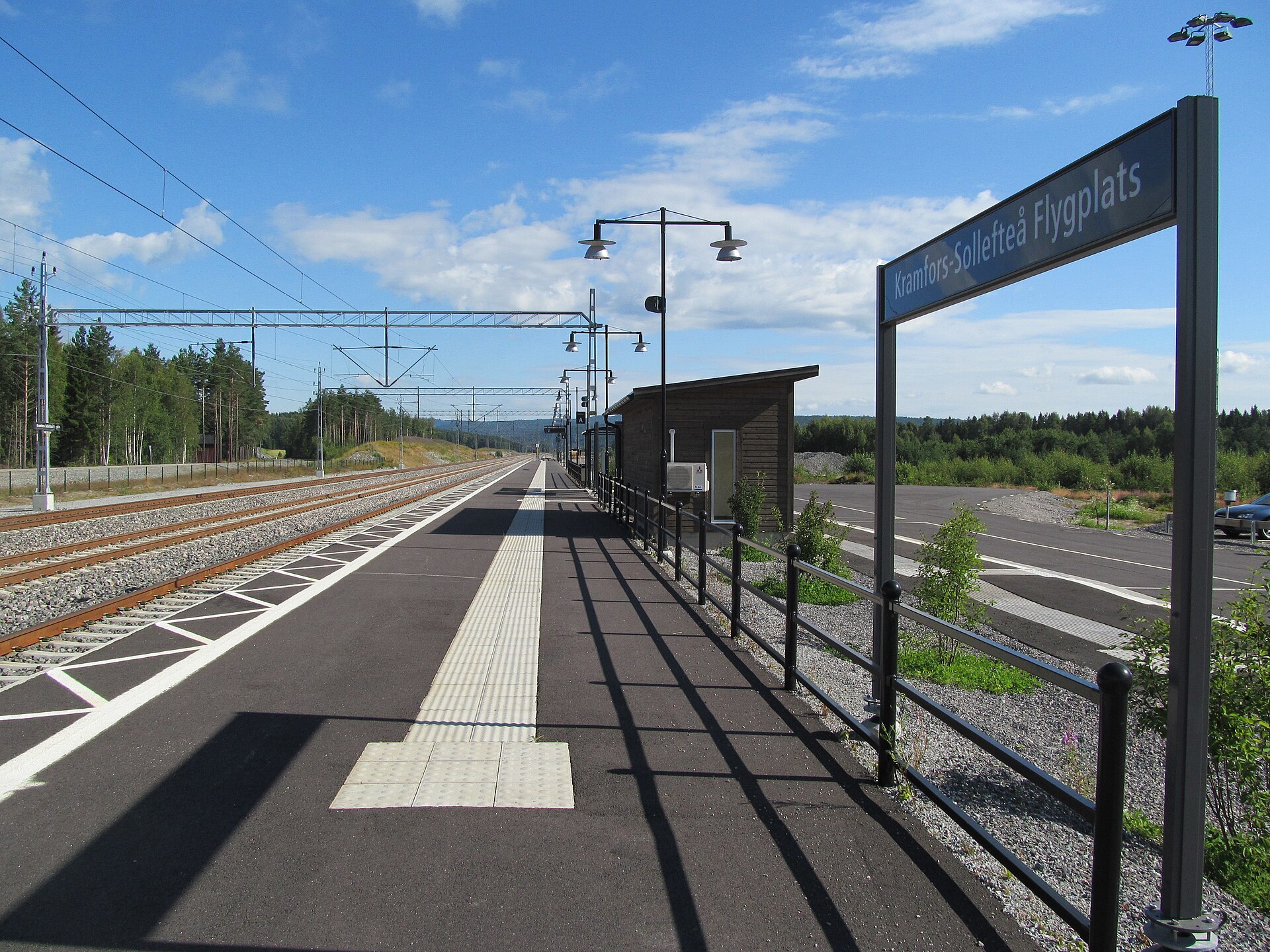 Perrongen vid Västeraspby station med en skylt där det står Kramfors-Sollefteå Flygplats