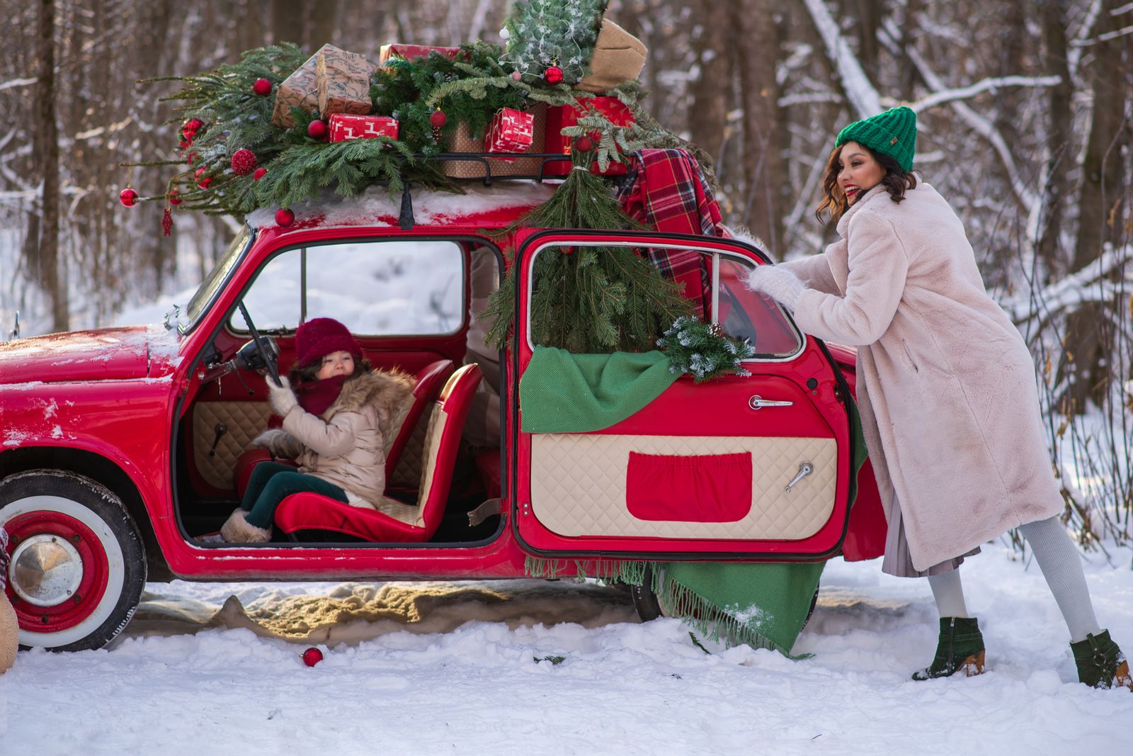 En julgran och paket lastade på en bil i ett snöigt landskap