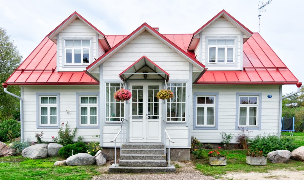 Vitt trähus med rött plåttak, typiskt svenskt bostadshus