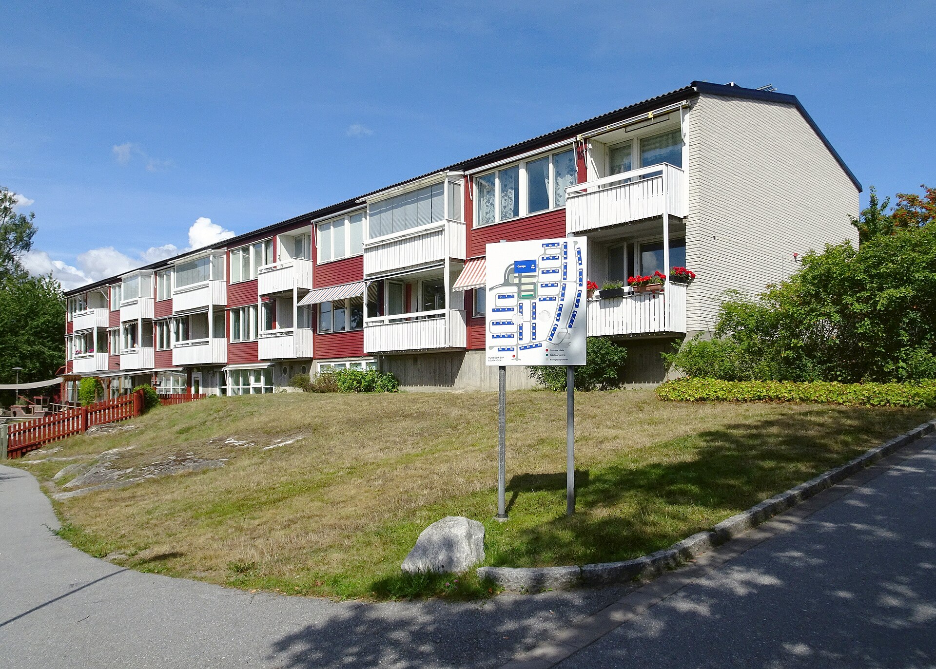 Lamellhus från början av sjuttiotalet med balkonger mot en gräsbacke