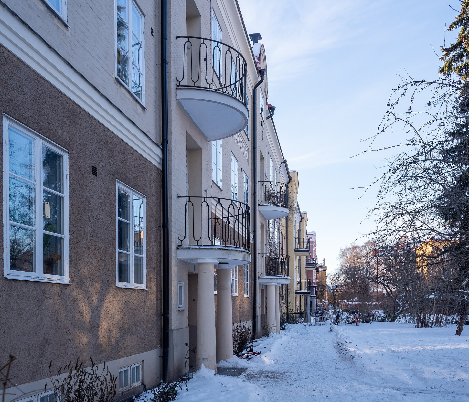 Flerbostadshus med runda balkonger och smidesräcken en vinterdag