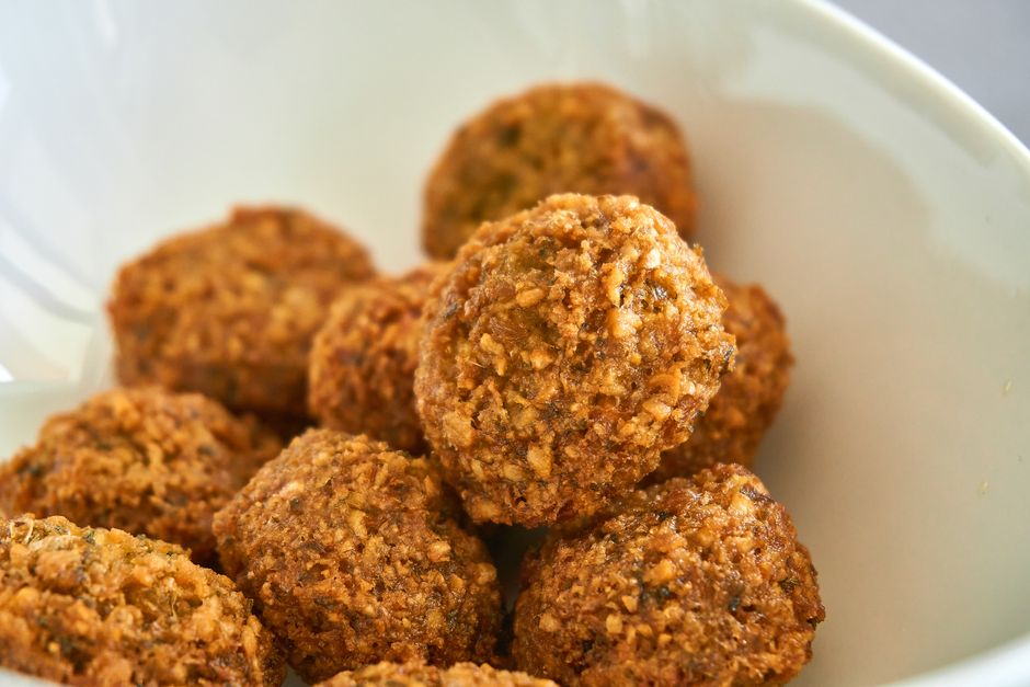 Gyllene friterade falafelbollar i en vit skål