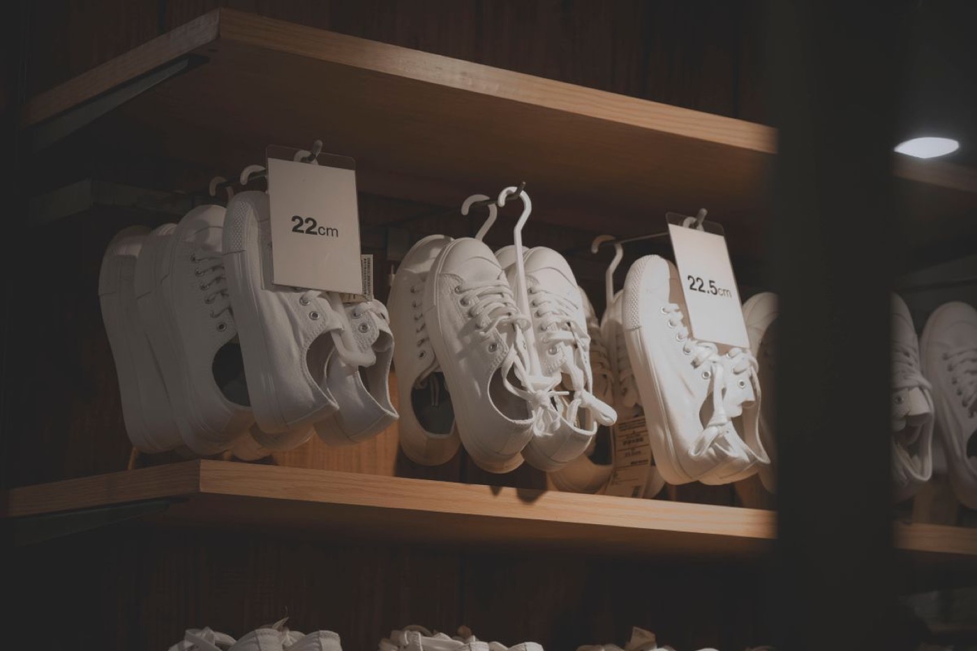Vita sneakers på en butikshylla märkta med storlek i centimeter