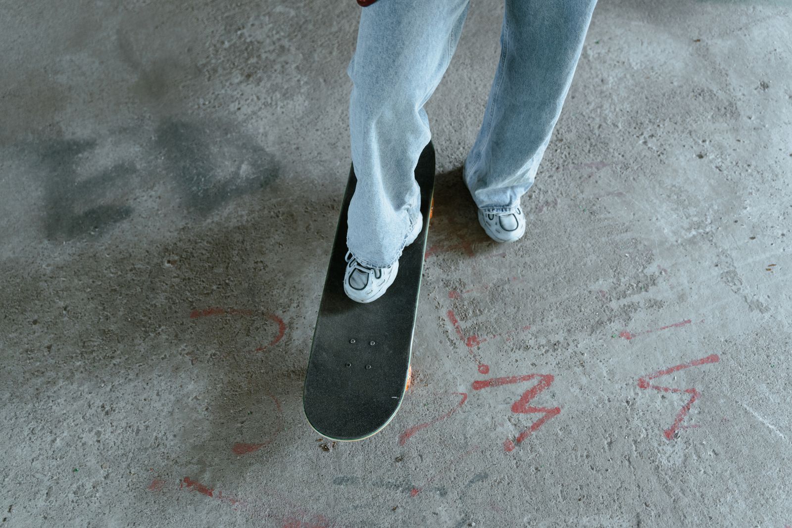 Närbild på vita skateskor när en skateboardåkare lutar brädan i en park