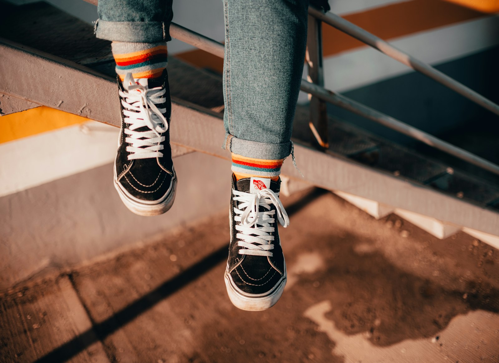Svarta höga kanvassneakers med vit sula och vita skosnören burna till uppvikta jeans