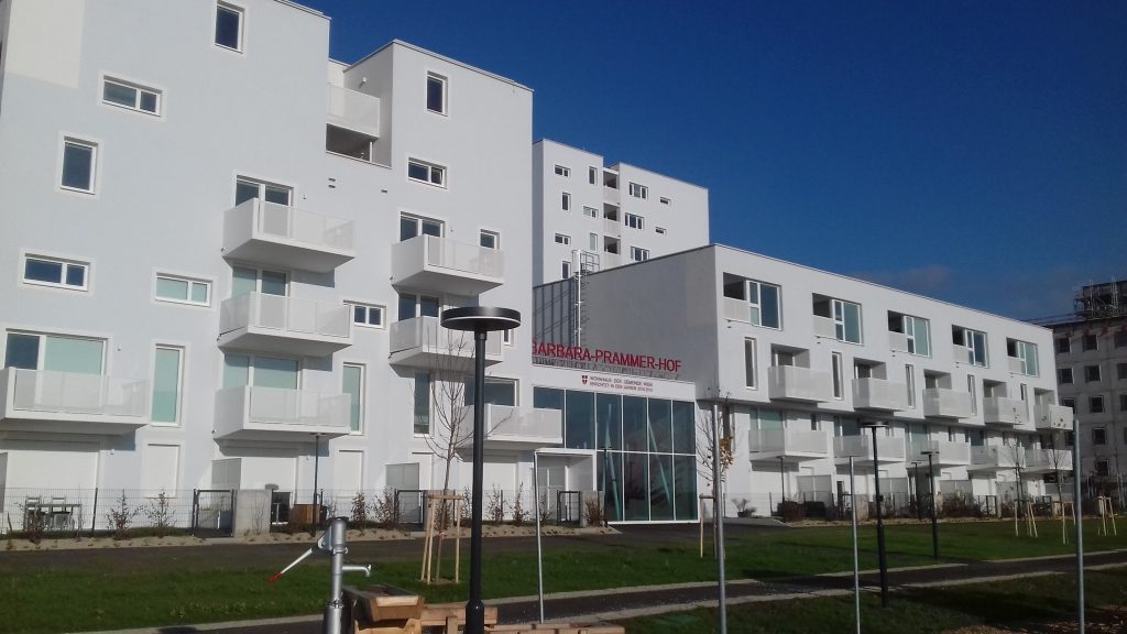 Barbara-Prammer-Hof i Wien, ett vitt bostadskvarter med balkonger och skylten Wohnhaus der Gemeinde Wien