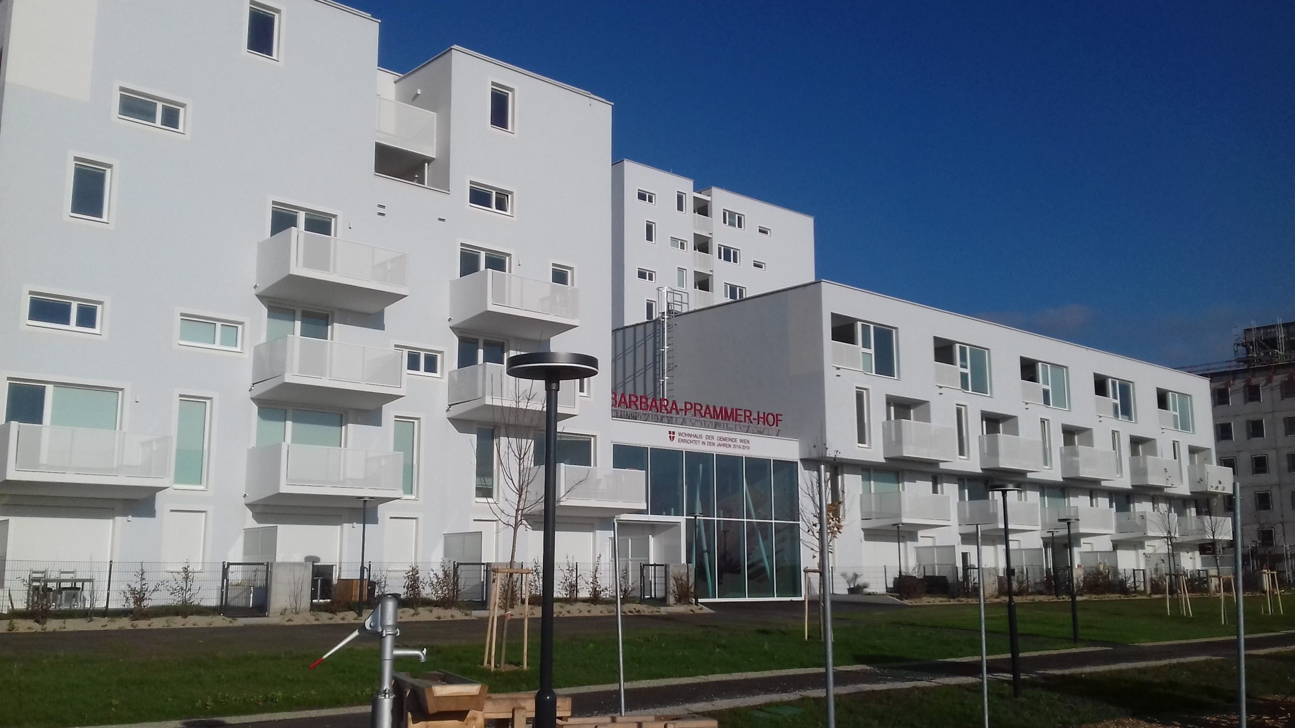 Barbara-Prammer-Hof i Wien, ett vitt bostadskvarter med balkonger och skylten Wohnhaus der Gemeinde Wien