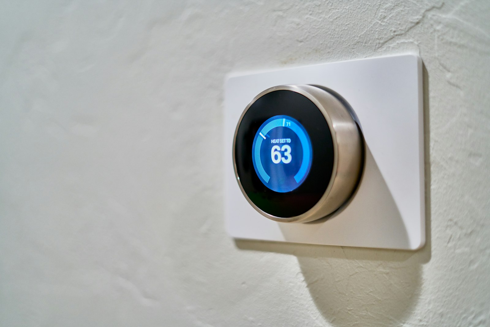 Uppkopplad smart termostat på en vägg som styr fastighetens värme