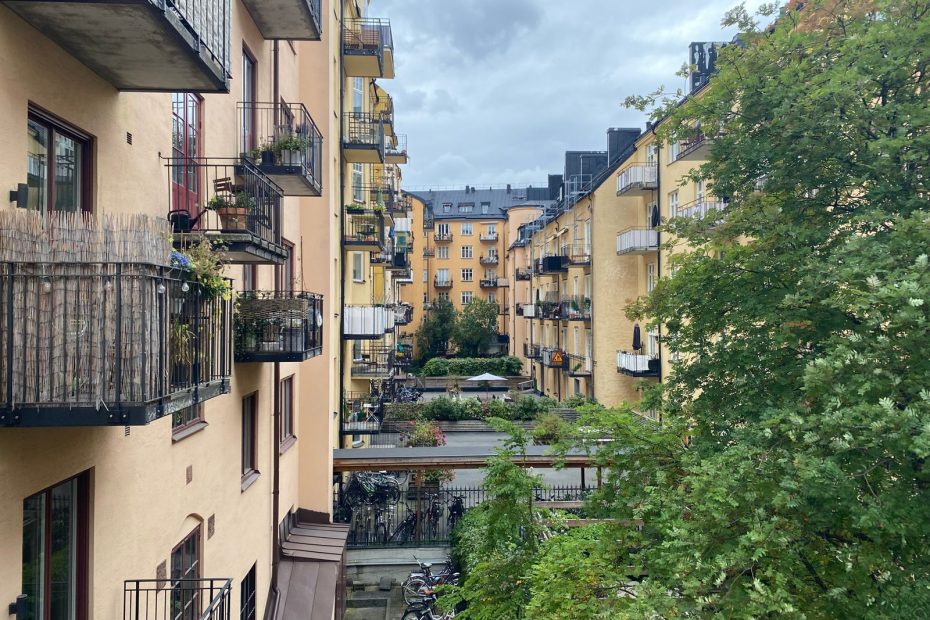 Innergård till ett flerbostadshus med balkonger, grönyta och cykelparkering