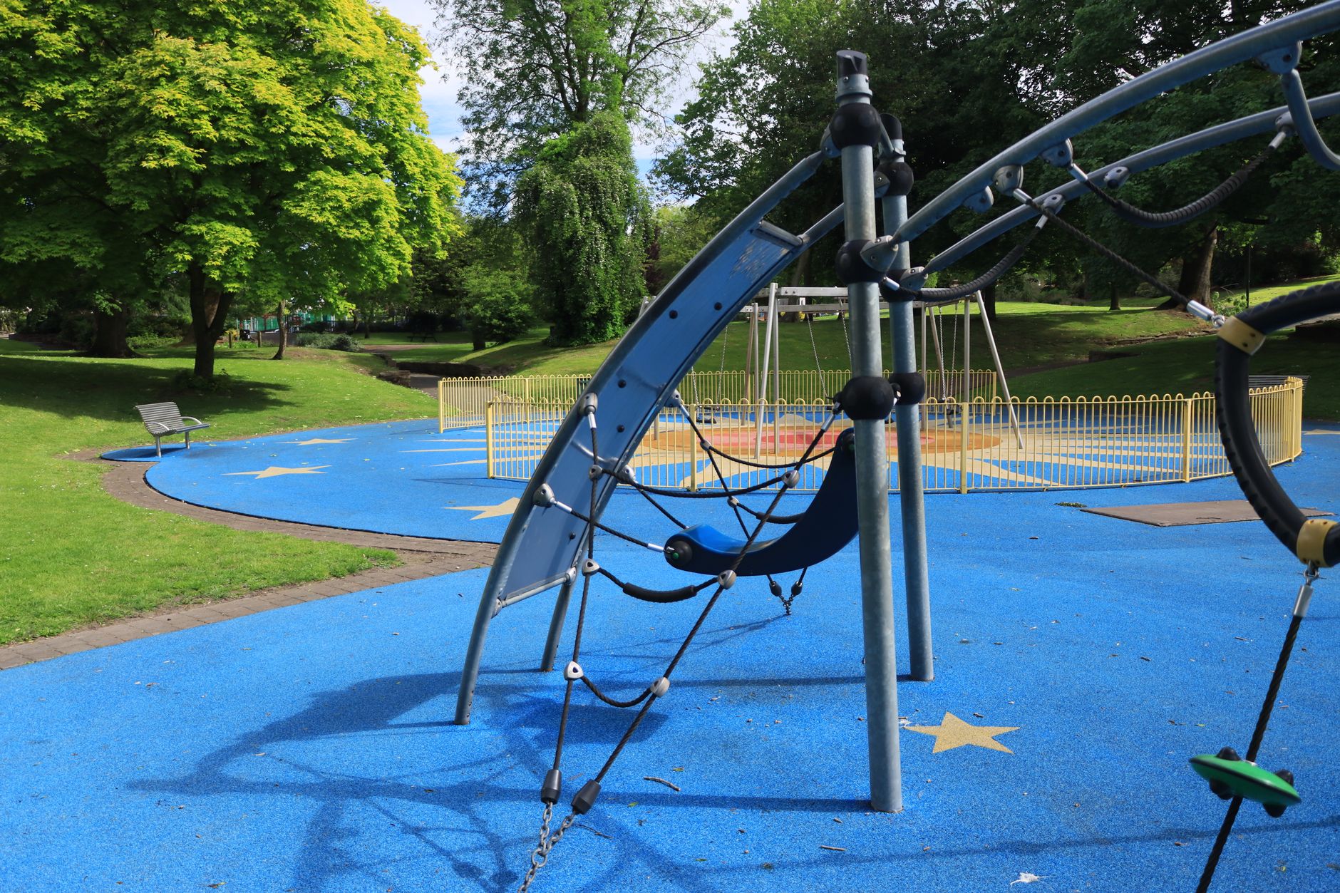 Klätterställning på gjutet blått gummiunderlag på en lekplats i en park