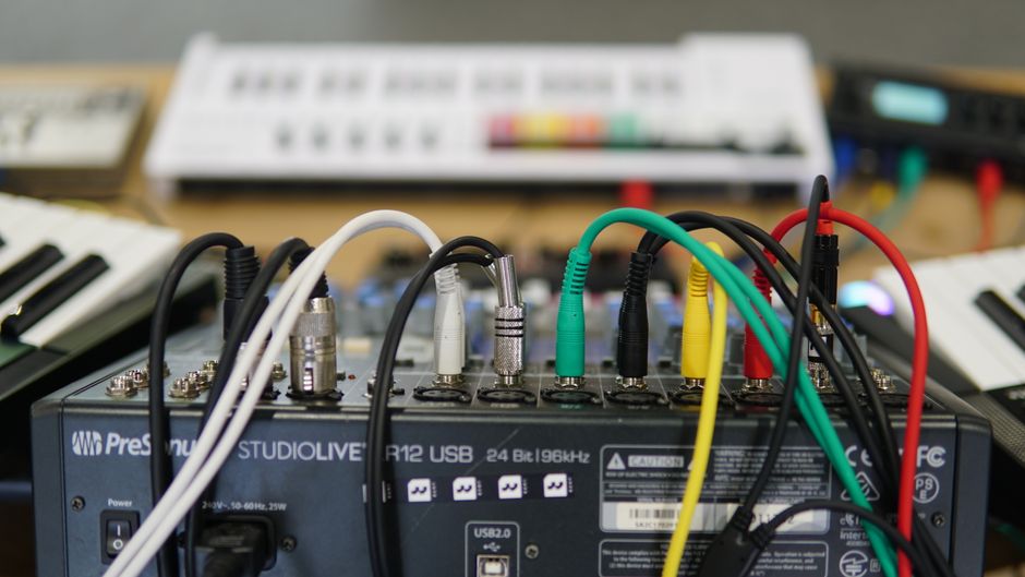 Patch cables connected to an audio interface in a hardware setup