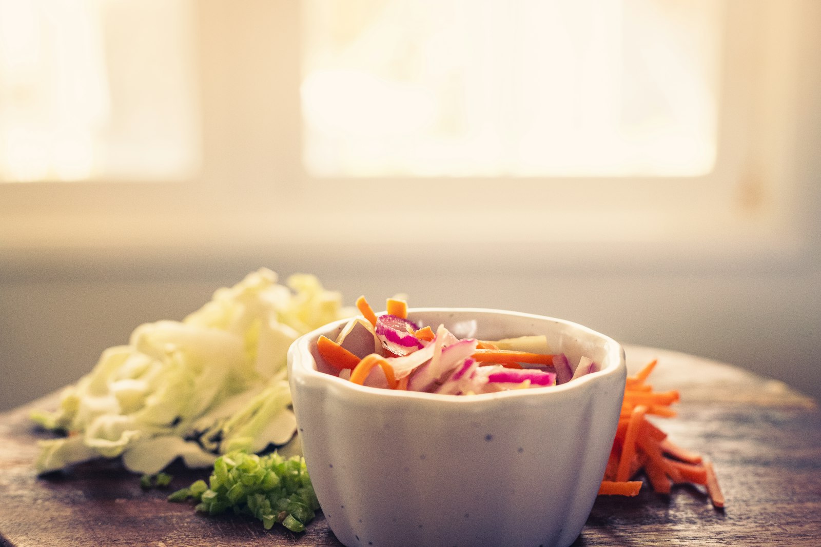 Ättikslagd kålsallad med vitkål, morot och rödlök i en liten skål