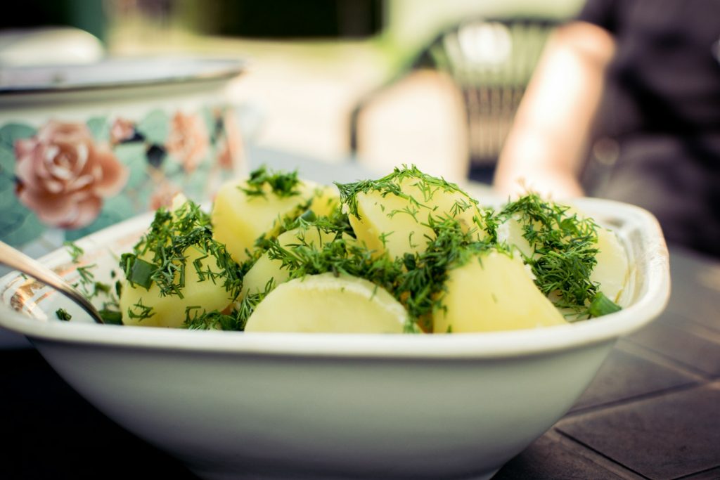 Kokt potatis toppad med färsk dill i en vit skål
