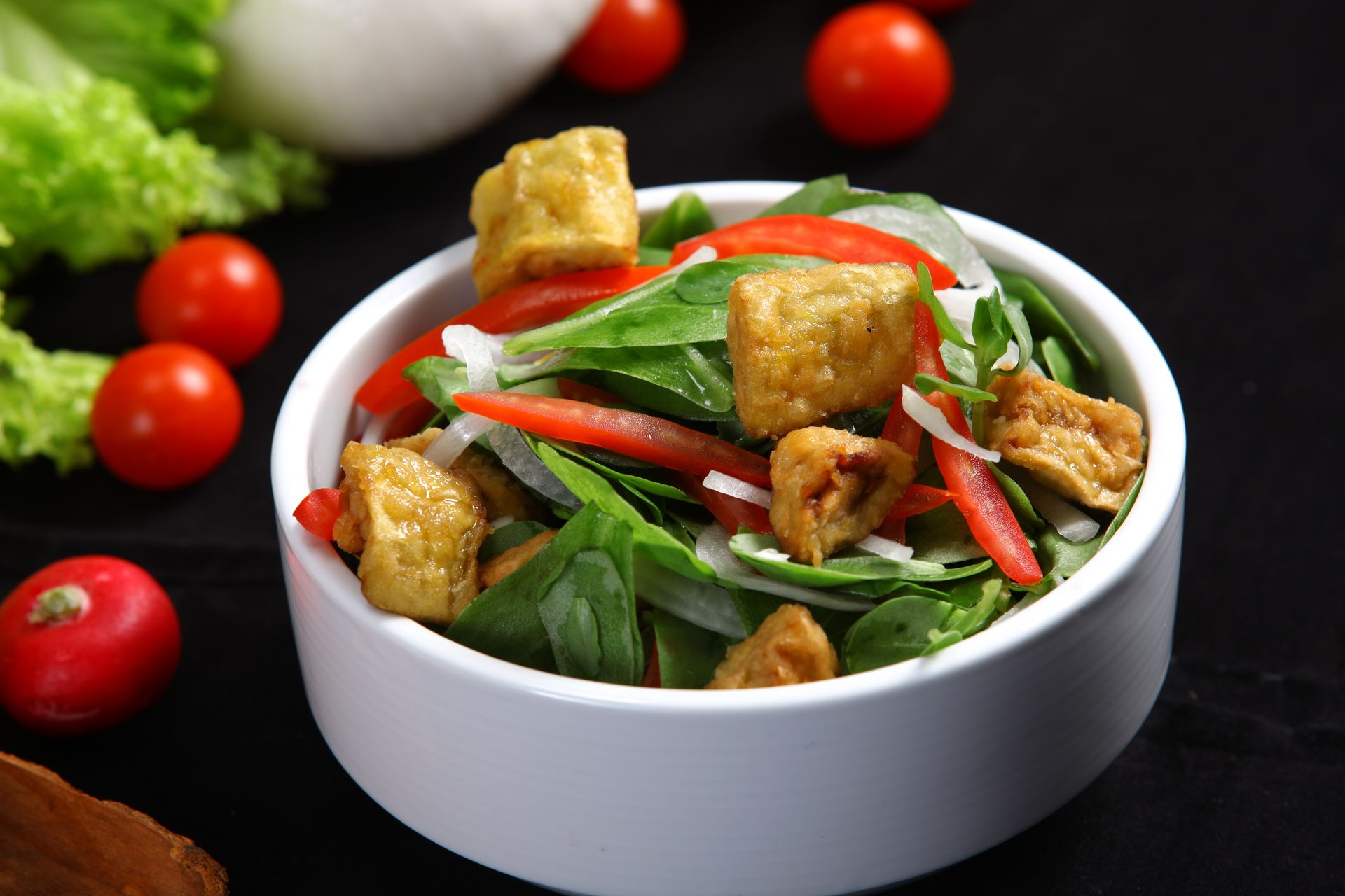 Stekt tofu i tärningar på bädd av sallad, paprika och tomat