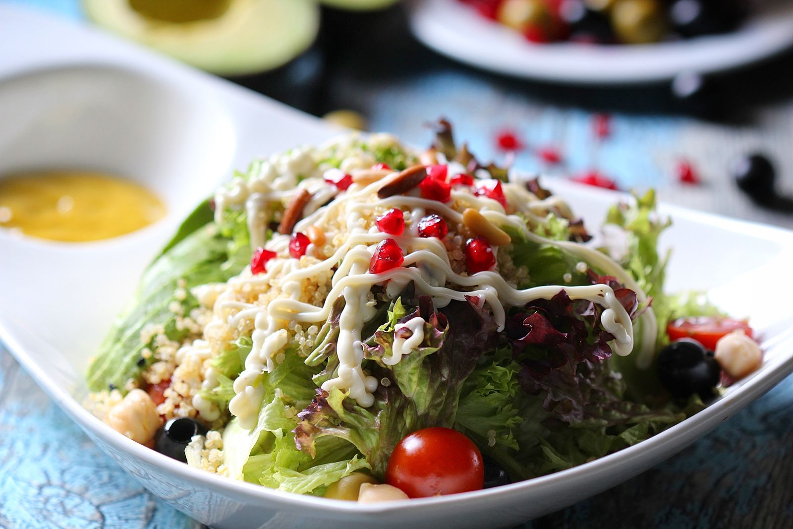 Sommarsallad med bladsallad, quinoa, kikärtor, granatäpple och krämig dressing