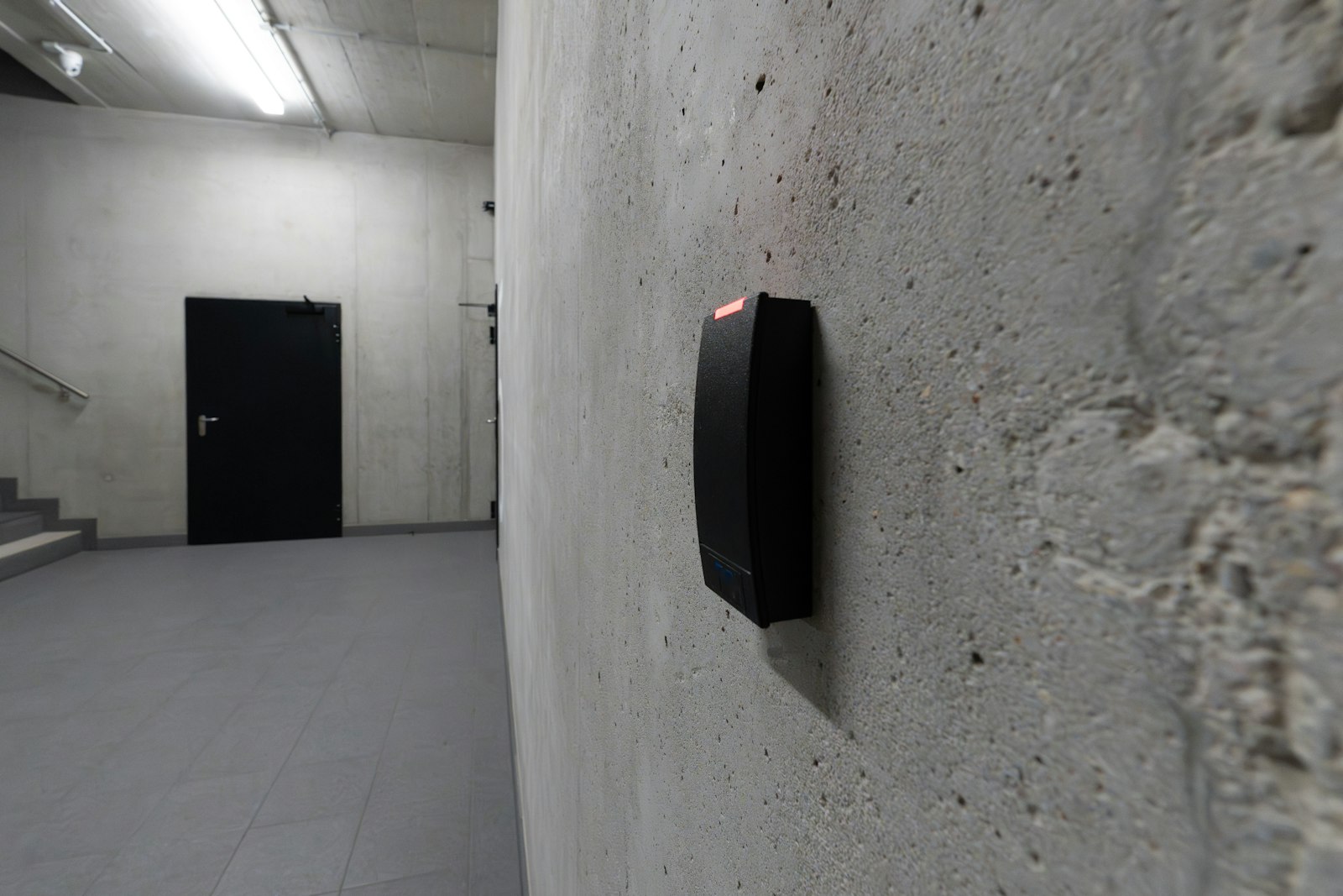 Taggläsare för passersystem på betongvägg i ett trapphus