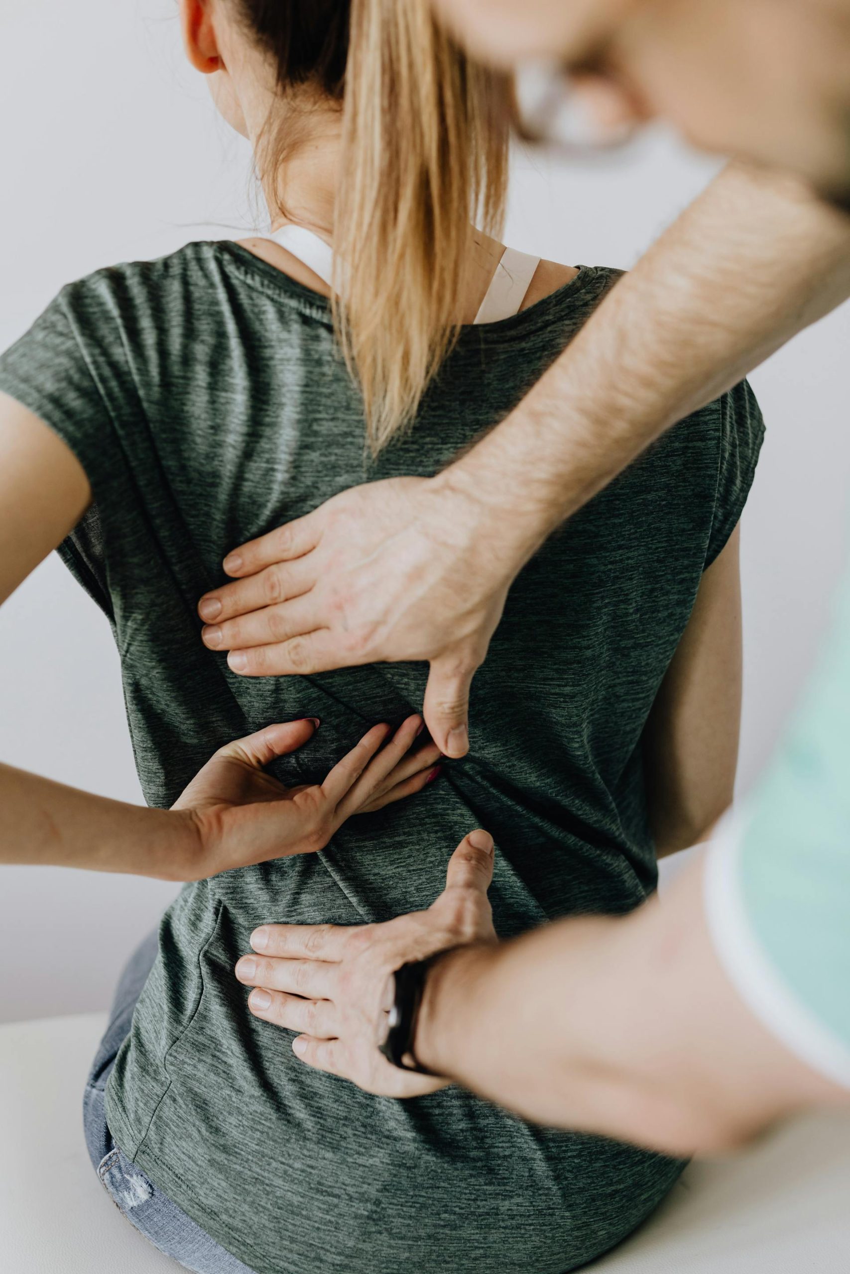 Patient visar var det gör ont i ryggen för en terapeut på en behandlingsbänk