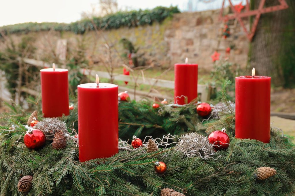 Adventskrans med fyra röda ljus och granris