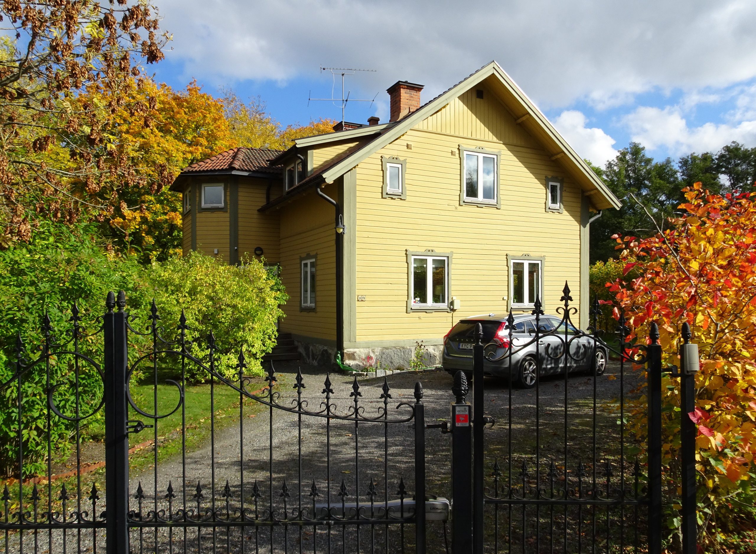 Gul sekelskiftesvilla i trä på Lidingö en höstdag