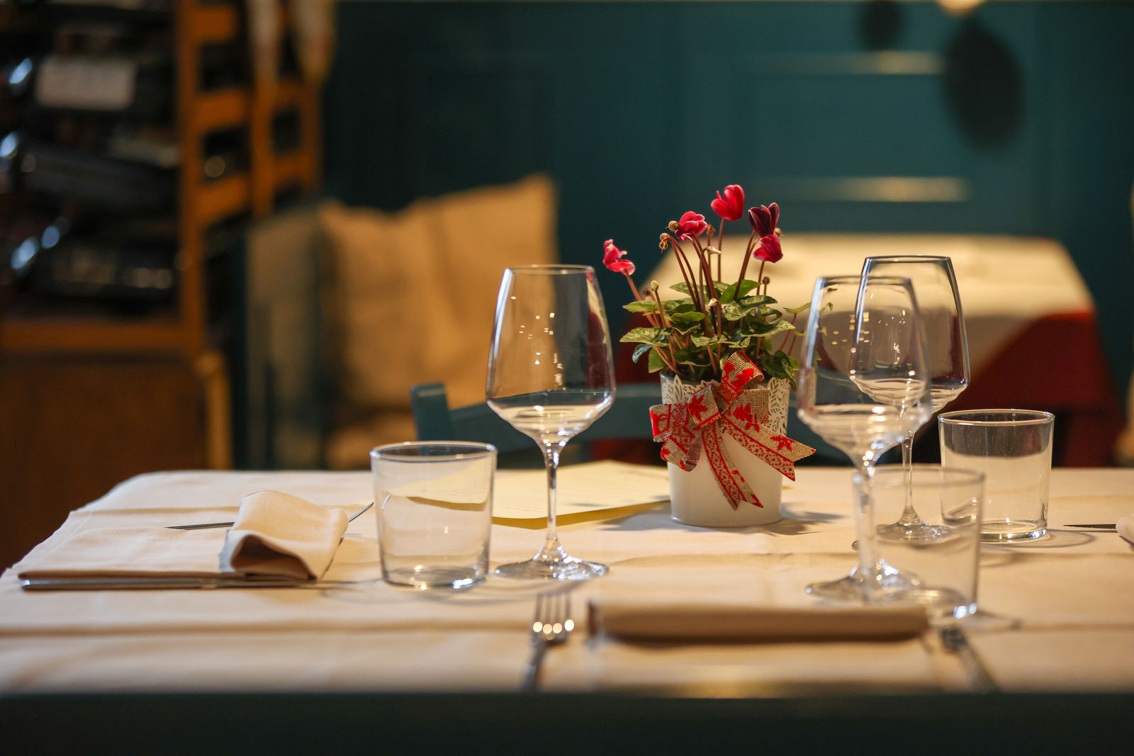 Dukat bord med vinglas och blommor i levande ljus på en mysig restaurang