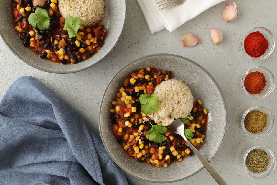 Skålar med vegansk svartböns- och majschili med ris