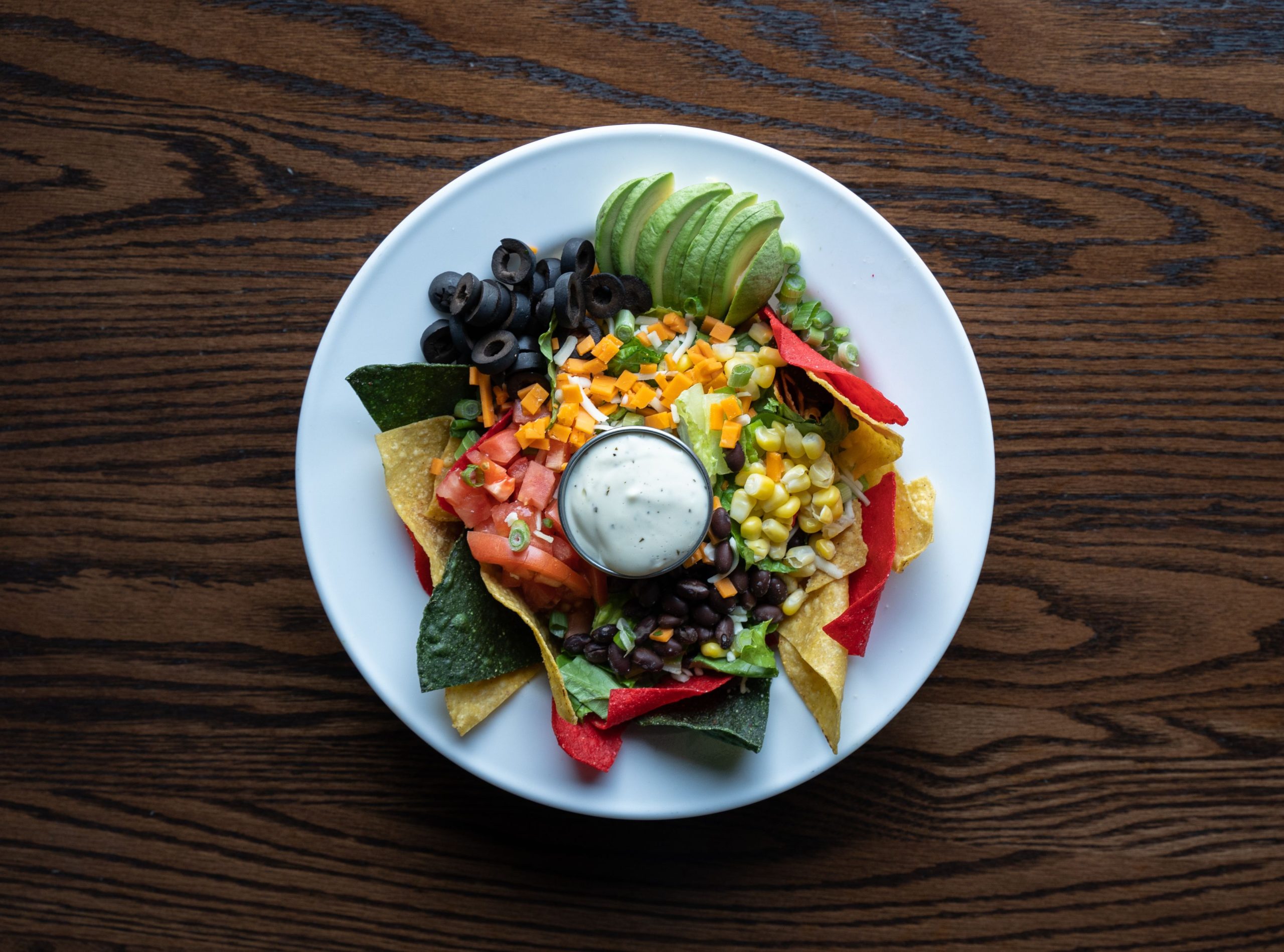 Loaded nachos med svarta bönor, majs, avokado, oliver och vegansk ostsås