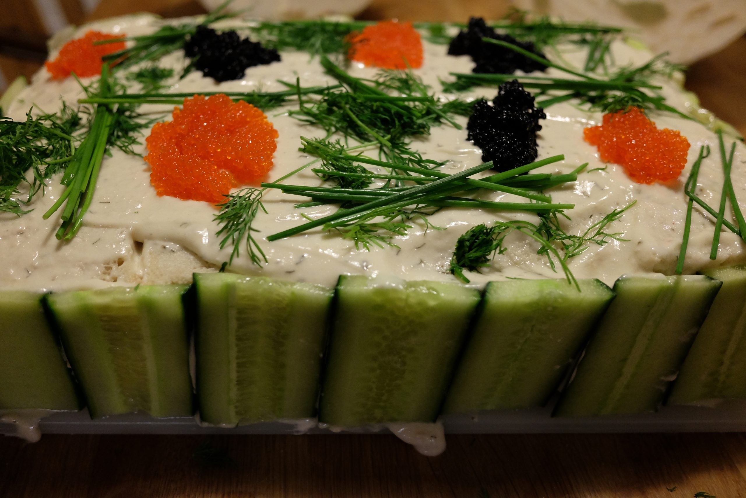 Vegansk smörgåstårta klädd med gurkskivor, toppad med krämig majonnäs, dill, gräslök och vegansk tångkaviar