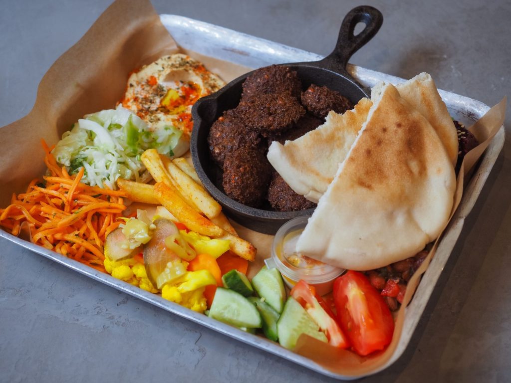 Bricka med falafel, hummus, pitabröd, morotssallad, inlagda grönsaker och tomat
