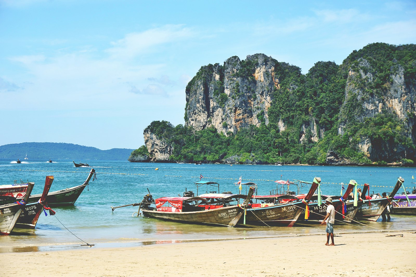 Longtailbåtar på en strand i Thailand