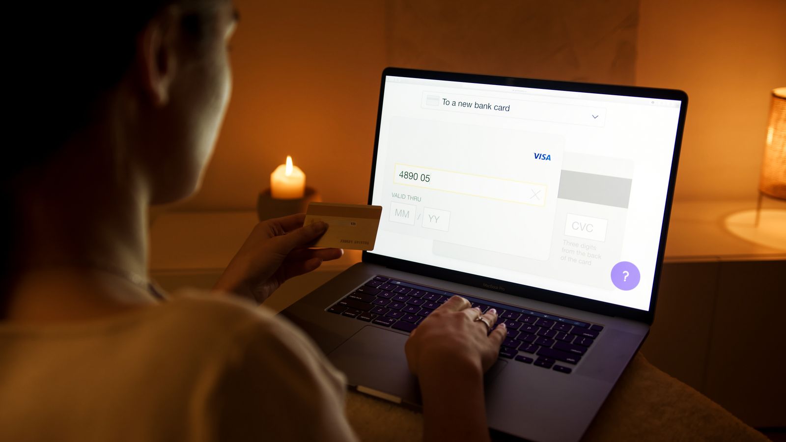 Person använder internetbanken på en laptop en kväll