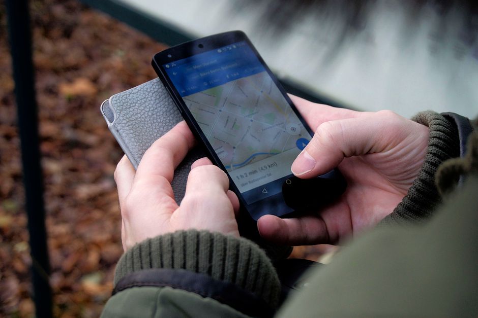 Händer som använder en kartapp i en mobil