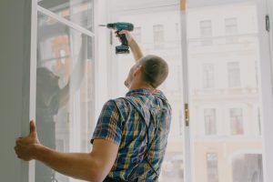 Man borrar i en fönsterkarm under en renovering i en lägenhet i ett flerbostadshus