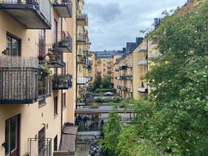 Innergård med balkonger, cyklar och grönska mellan gula flerbostadshus