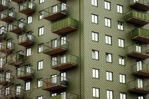 Fasad på ett modernt flerbostadshus med balkonger, där varje lägenhet är en enhet i förvaltningsavtalets prissättning